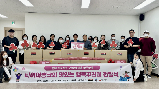 김정규(왼쪽 8번째) 타이어뱅크 회장이 관계자들과 지난 4일 세종특별자치시 보람동에 위치한 종합복지센터에서 행복꾸러미 전달식 후 기념사진을 찍고 있다. 타이어뱅크 제공
